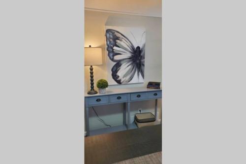 a room with a desk with a butterfly painting on the wall at Cindy's Super Ranch Home in West Chester