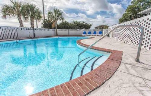 a large swimming pool with blue water and a fence at Just Shy of the Bridge - Waterway Condo 110 in Wilmington