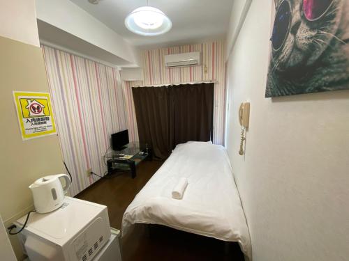 Pokój szpitalny z łóżkiem i telefonem w obiekcie Exsaison Shirokita 511 w Osace