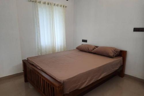 1 cama grande en un dormitorio con ventana en BMRAN Apartment A en Ernakulam