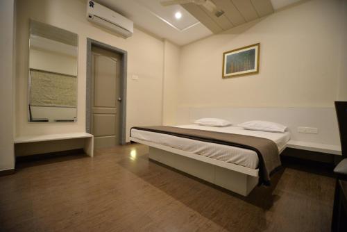 a bedroom with a bed and a window at Hotel Naman in Solapur