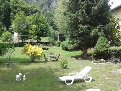 a yard with a bench and a table and two cats at Hôtel du Val d'Aure in Cadéac