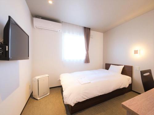 a hotel room with a bed and a flat screen tv at Hotel chez toi Kanonji in Kanonji