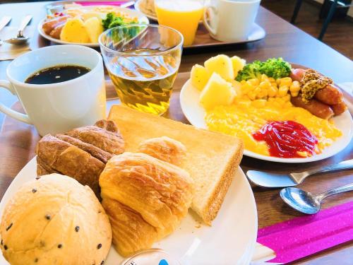 a table with plates of breakfast foods and a cup of coffee at Hotel chez toi Kanonji in Kanonji