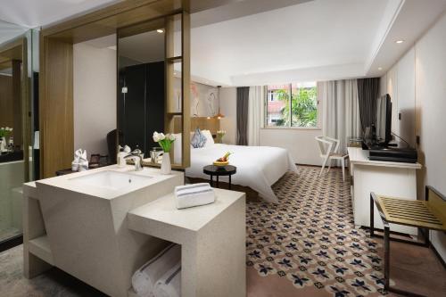 a bathroom with a sink and a bed in a room at Paco Hotel Gangding Metro Guangzhou-Free Shuttle Bus fir Canton Fair in Guangzhou