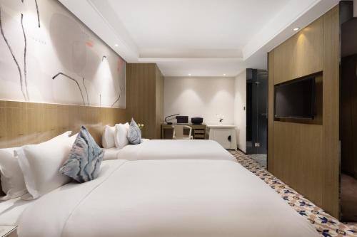 Postel nebo postele na pokoji v ubytování Paco Hotel Gangding Metro Guangzhou-Free Shuttle Bus fir Canton Fair