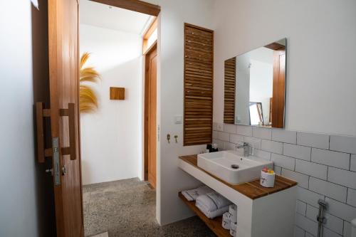 a bathroom with a sink and a mirror at Tiga Studios - Adults Only in Kuta Lombok