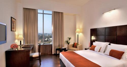 una camera d'albergo con un letto e una grande finestra di Comfort Inn Tulip Heights a Bathinda