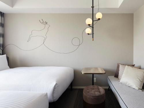 a hotel room with a bed and a couch at Granbell hotel Tanuki, Sapporo in Sapporo
