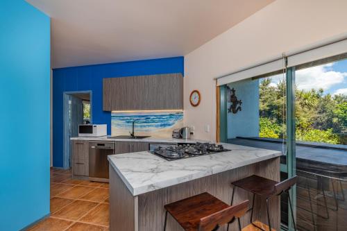 a kitchen with blue and white walls and a counter at The Kereru's Nest in Kaeo