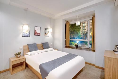 a bedroom with a large white bed and a window at Harbin Hash International Youth Hostel Harbin West Station in Harbin
