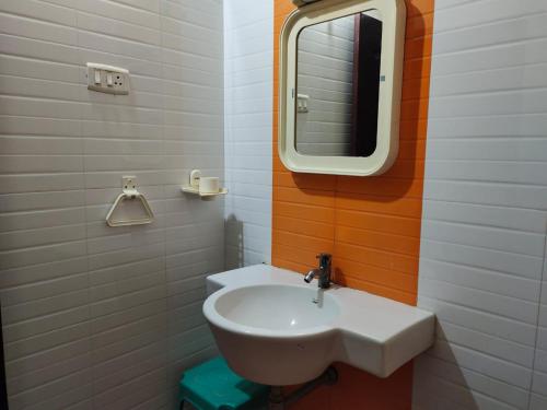 bagno con lavandino bianco e specchio di Hotel Geetha International a Tuticorin