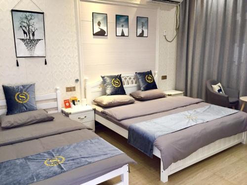 sypialnia z 2 łóżkami i niebieskimi poduszkami w obiekcie 百墅居•漫生活主题民宿 w mieście Luoshan