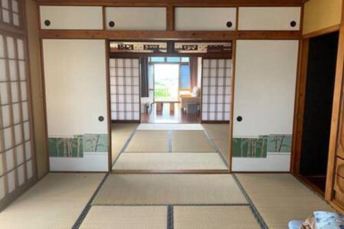 a room with a hallway with doors and a room with at Japanestジャパネスト in Tomigusuku
