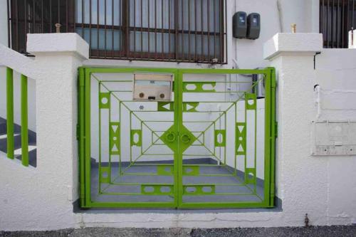 a green door on a building with a staircase at Japanestジャパネスト in Tomigusuku