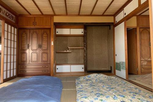 a room with a bed and two sliding glass doors at Japanestジャパネスト in Tomigusuku