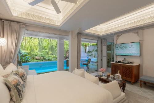 a bedroom with a large bed and a living room at The Inside House in Chiang Mai