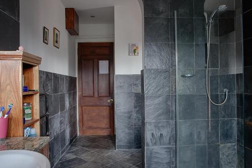 uma casa de banho com um chuveiro e uma porta de vidro em Netherbrae em Edimburgo
