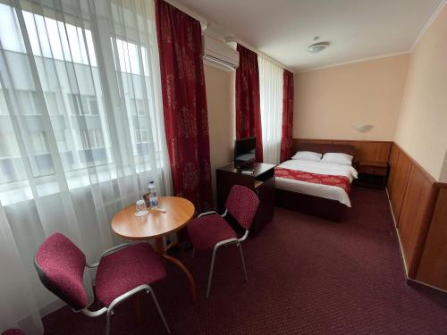 a hotel room with a bed and a table and chairs at Hotel Complex Ukraine in Luts'k