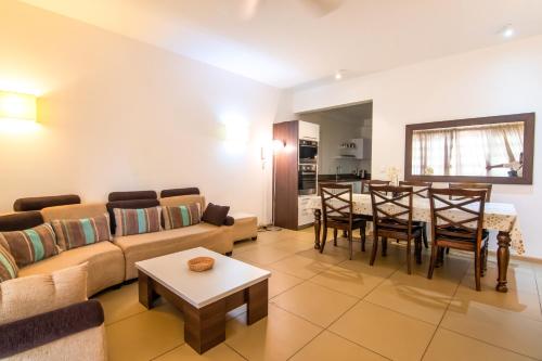 sala de estar con sofá y mesa en Two Bedroom Apartment with Garden and Pool Access - Azuri Village, Roches Noires, en Roches Noires