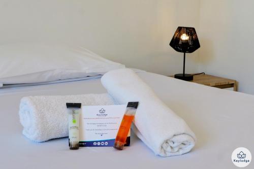 a hotel room with towels and a book on a bed at T2- Aux Pluies d'Or- 47m2- Sainte-Clotilde in Saint-François