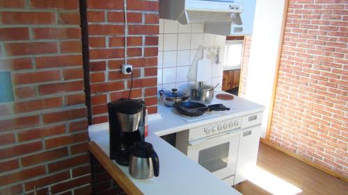 a kitchen with a stove and a brick wall at Livonia Matkamaja in Kilingi-Nõmme