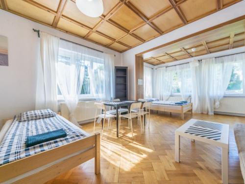 Cette chambre comprend deux lits, une table et des chaises. dans l'établissement House Managers - Vintage Sopot, à Sopot