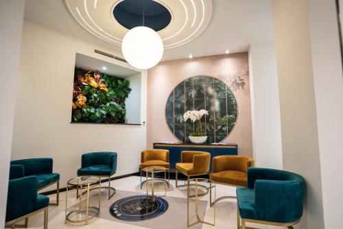 a waiting room with chairs and a table and a painting at Hôtel Univers in Nice