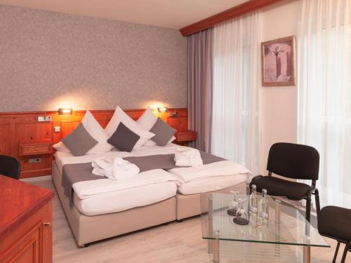 a hotel room with a bed and a glass table at Hotel Haus Gimken in Essen