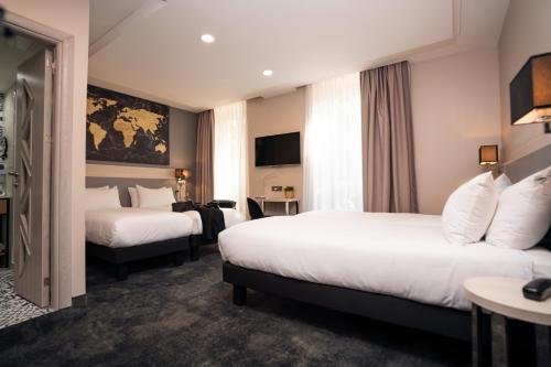 a hotel room with two beds and a tv at Hôtel Univers in Nice