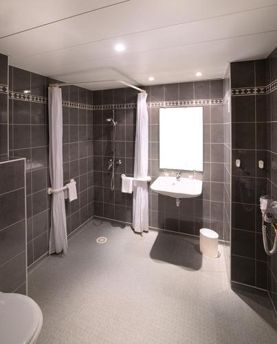 une salle de bain avec un lavabo, une douche et des toilettes dans l'établissement Hôtel Gloria & Avenue, à Lourdes
