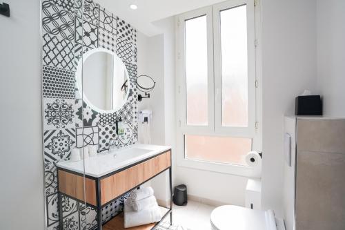 La salle de bains est pourvue d'un lavabo et d'un miroir. dans l'établissement Hôtel Univers, à Nice