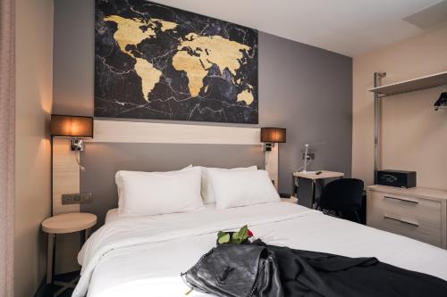 a bedroom with a large bed with a map on the wall at Hôtel Univers in Nice