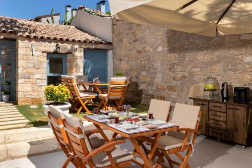 a patio with a table and chairs and an umbrella at EFLIN HAUS Historical Place & Monument in Cesme