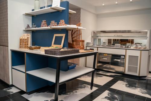a kitchen with blue walls and a table with food on it at Hôtel Univers in Nice