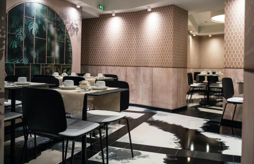 a restaurant with tables and chairs in a room at Hôtel Univers in Nice