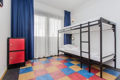 1 dormitorio con litera y suelo a cuadros en Bud Gett Hostels, en Groninga