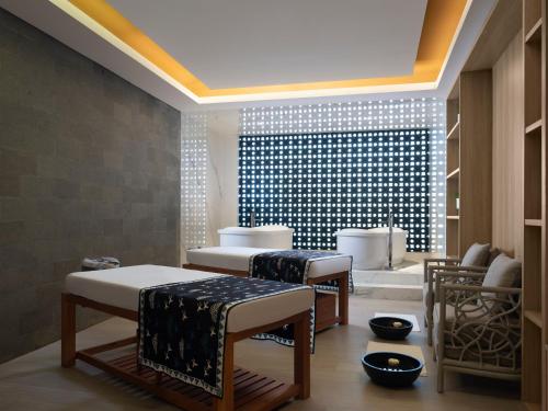 a room with three beds and a wall with lights at Novus Jiva Anyer in Anyer