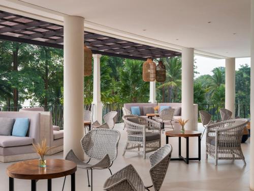a patio with wicker furniture and tables and chairs at Novus Jiva Anyer in Anyer