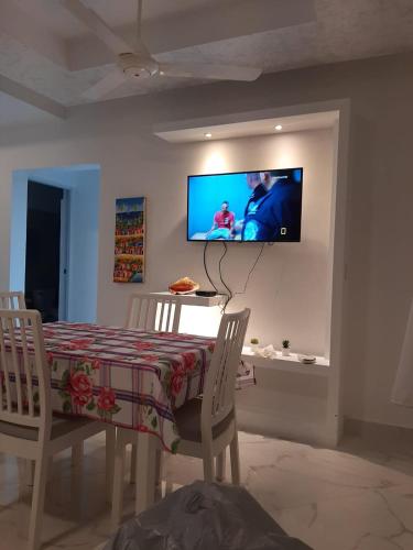 a dining room with a table and a tv on a wall at CASA MARAVILLOSA in Bayahibe
