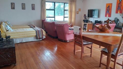 a living room with a wooden table and chairs at Goggas Nest BNB & Restaurant in Matsapha
