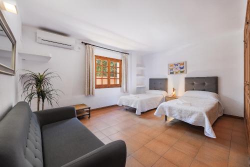 a living room with two beds and a couch at Villa Ramis by JS Villas in Cala de Sant Vicenc