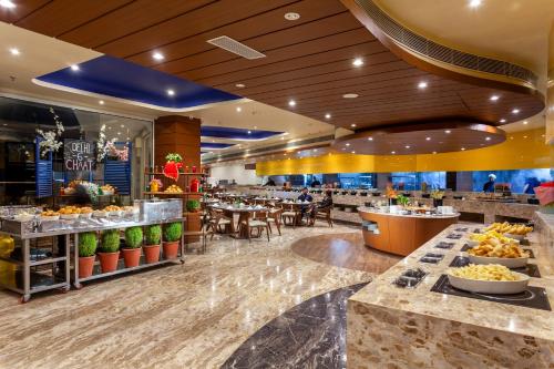 Un vestíbulo de un restaurante con mesas y sillas. en jüSTa Sajjangarh Resort & Spa, Udaipur, en Udaipur