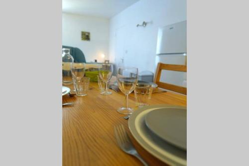 a table with wine glasses and a plate on it at JOE BAY in Saint Malo