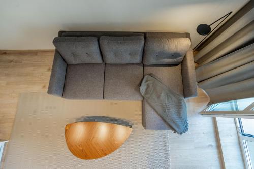 a living room with a couch with a wooden table at Varpų studija in Klaipėda