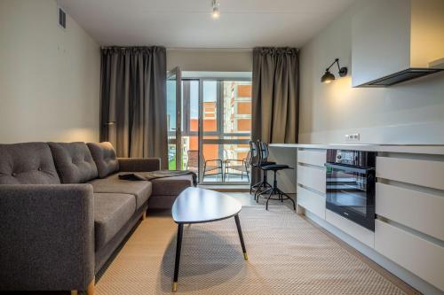 a living room with a couch and a table at Varpų studija in Klaipėda