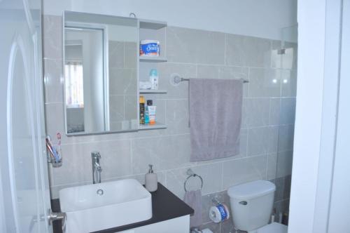 a bathroom with a sink and a toilet and a mirror at CASA MARAVILLOSA in Bayahibe