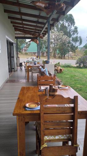 a wooden table and chairs on a patio at Goggas Nest BNB & Restaurant in Matsapha