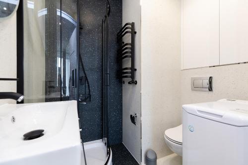 uma casa de banho com um chuveiro, um lavatório e um WC. em Cozy apartment Kazimierza 48, Wola em Varsóvia