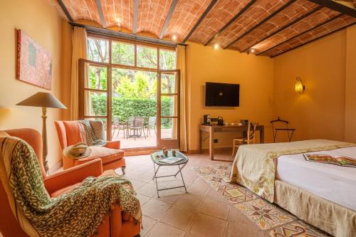 a bedroom with a bed and a chair and a window at Hotel Mas La Boella in La Canonja
